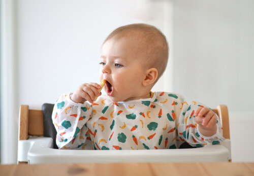 Little baby eating her snack herself